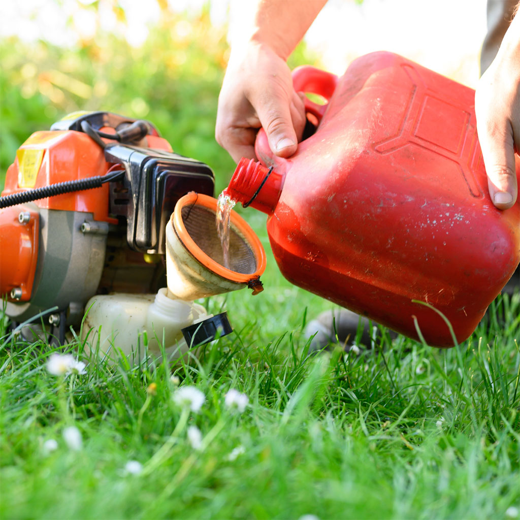 Pouring fresh gas into a mower
