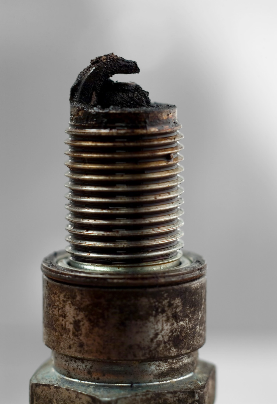 Fouled and dirty spark plug showing carbon buildup